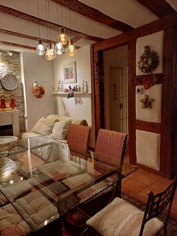 a living room with a glass table and a couch at La Maison des Tanneurs in Ribeauvillé