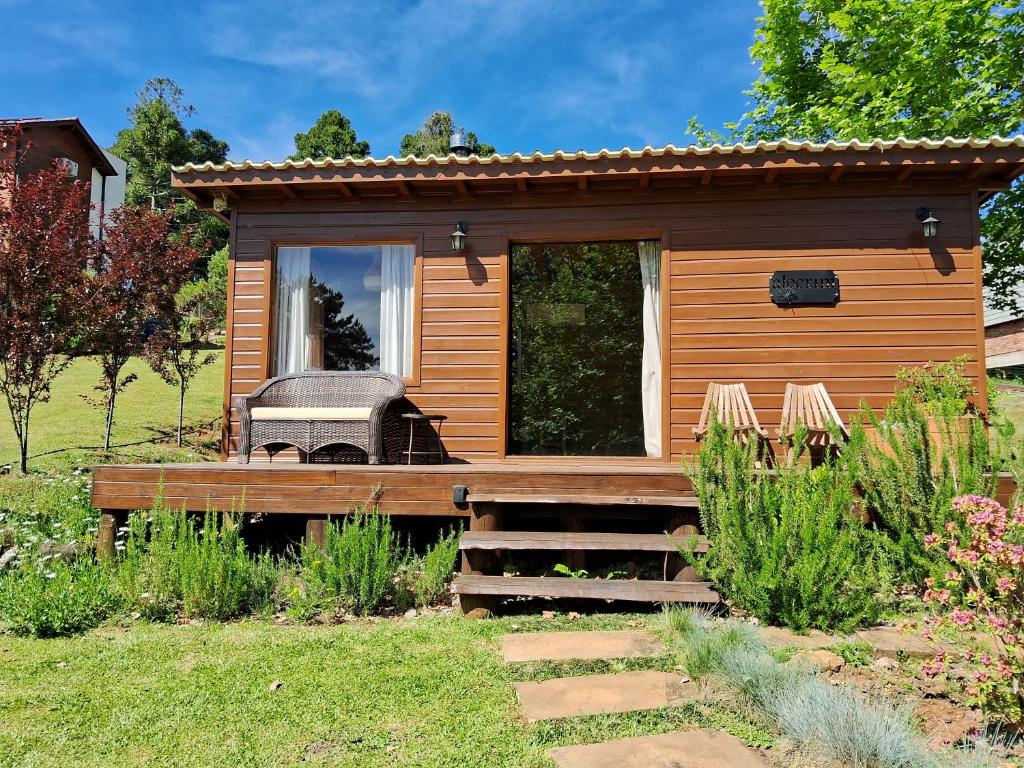 a small wooden cabin with a grill in a yard at Dolce Far Niente - Alecrim in São Francisco de Paula