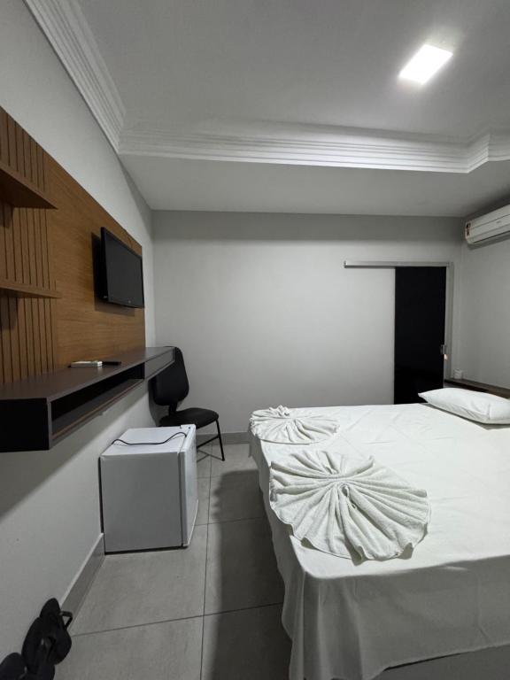 a hotel room with a bed and a tv at Hotel Samaritano in Montes Claros