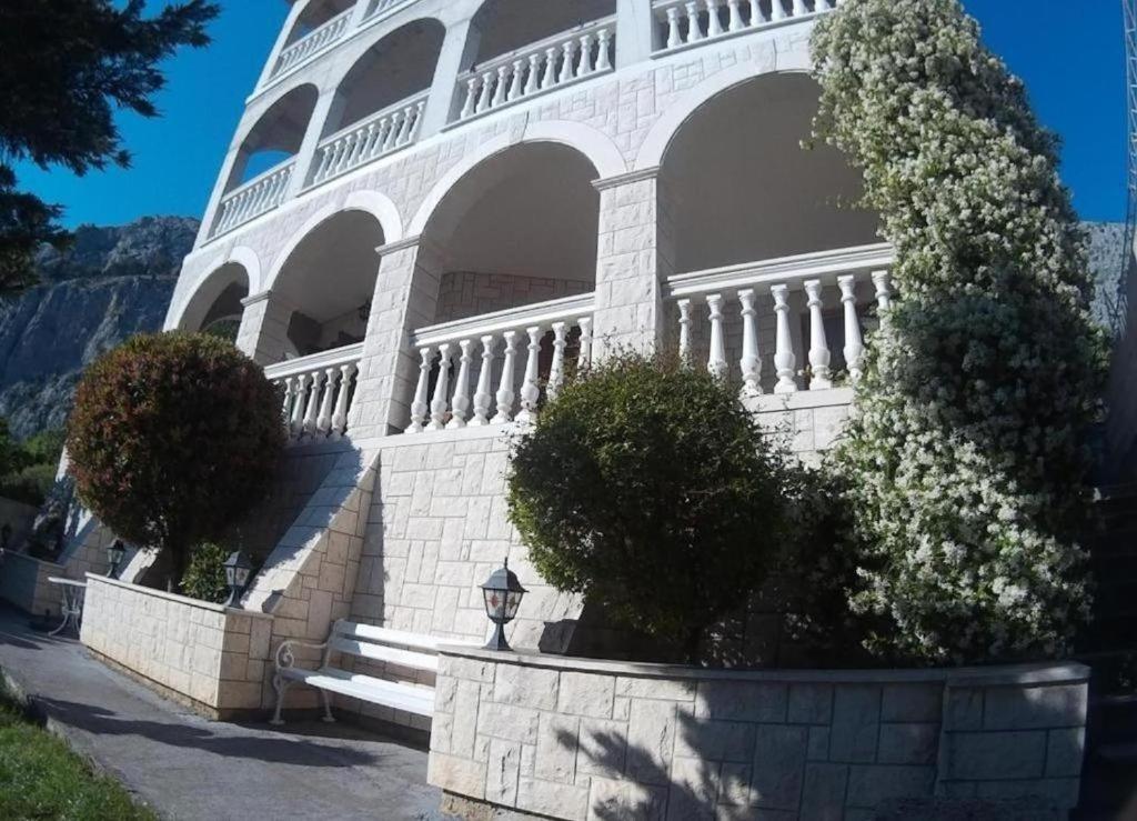a white building with trees in front of it at Apartment Adriatic panorama view in Omiš