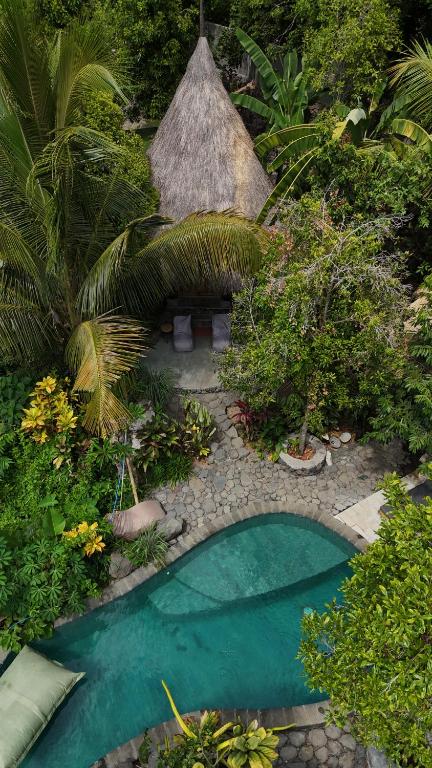 a small pool in the middle of a garden at Les Garden villa in Tejakula