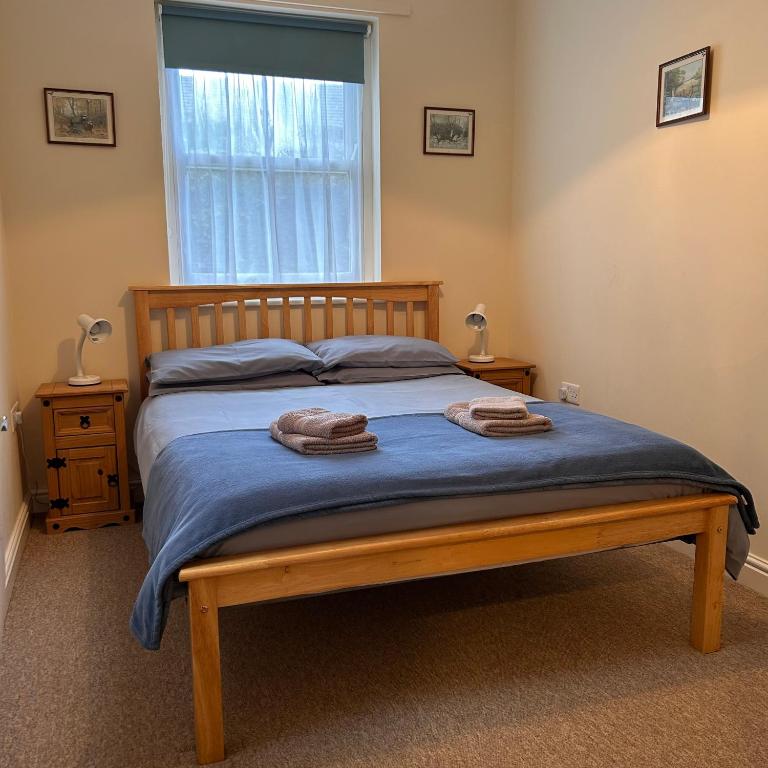 a bedroom with a bed with two towels on it at Apartment 2 at 2 Bell Street in Talgarth