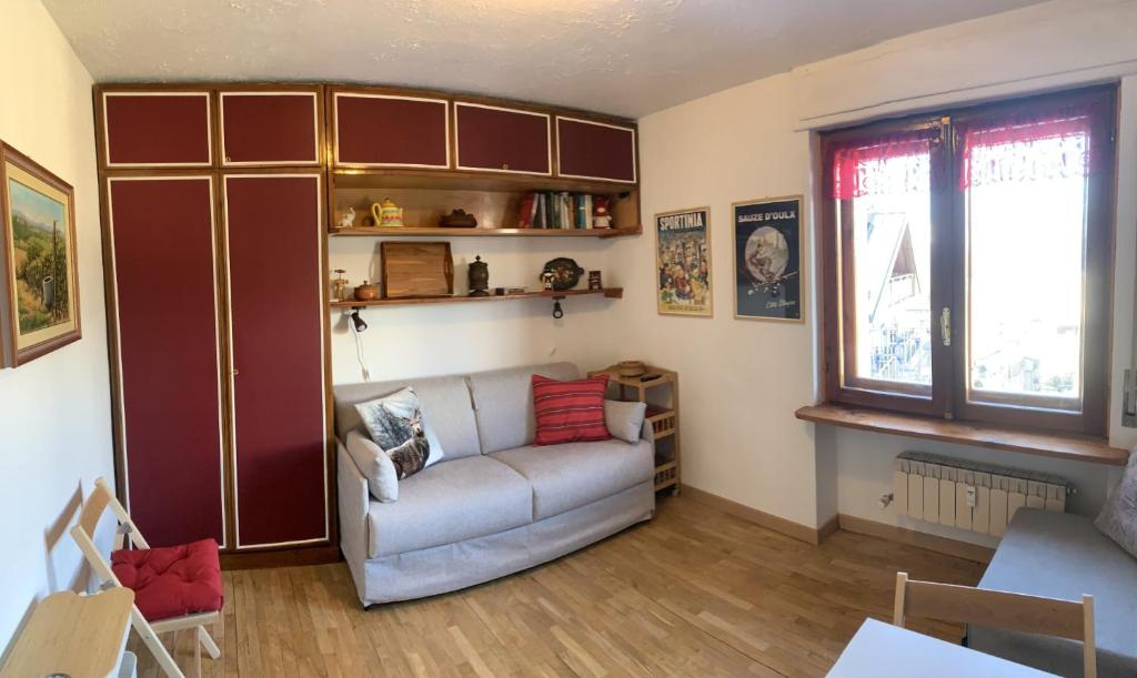 a living room with a couch and a window at Studio Seguret in Sauze d'Oulx