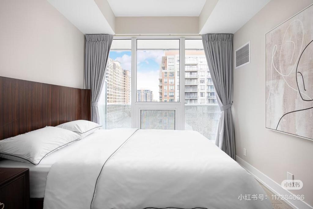 ein Schlafzimmer mit einem großen Bett und einem großen Fenster in der Unterkunft KK Hotel in Markham