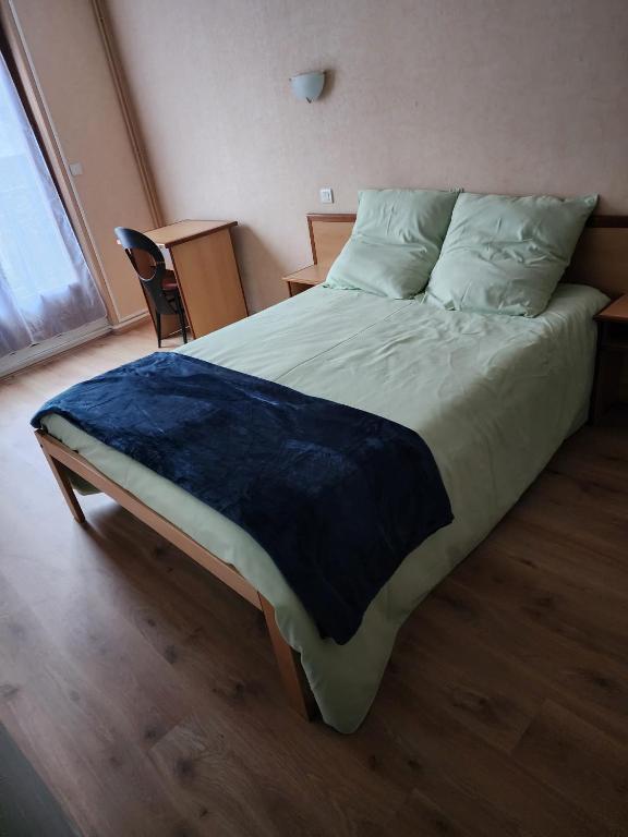 a bed with a blue blanket on it in a room at La Bona Taula By A&J in Rochefort-Montagne