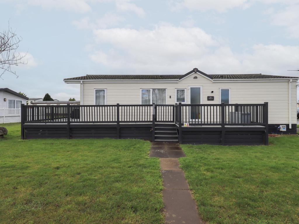 a house with a black fence and a yard at Lily's Lodge in Morecambe
