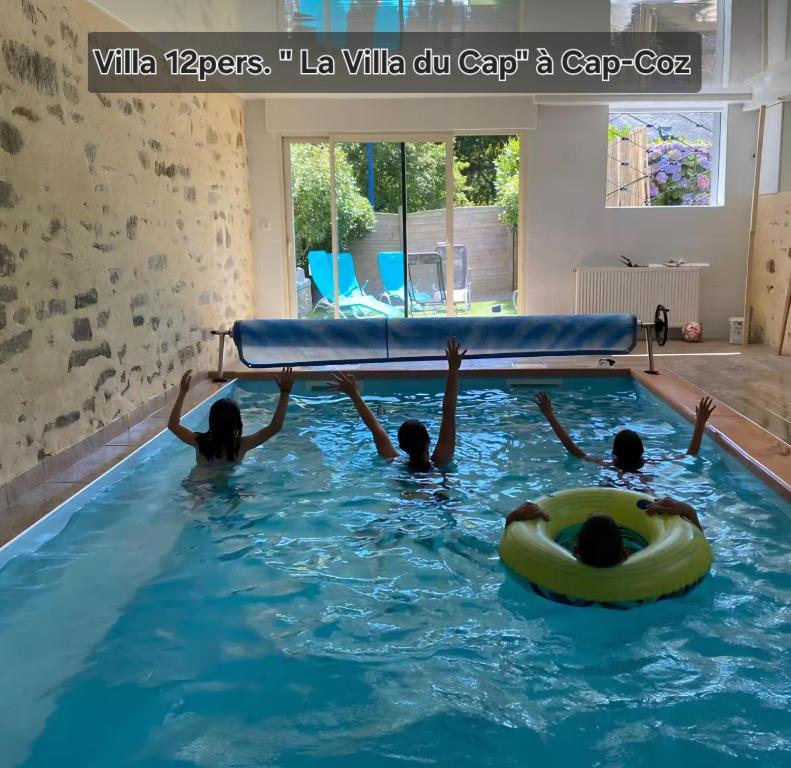 a group of people in a swimming pool at "La Villa du Cap" avec piscine intérieur, billard et à 5 minutes de la plage et des commerces! in Fouesnant