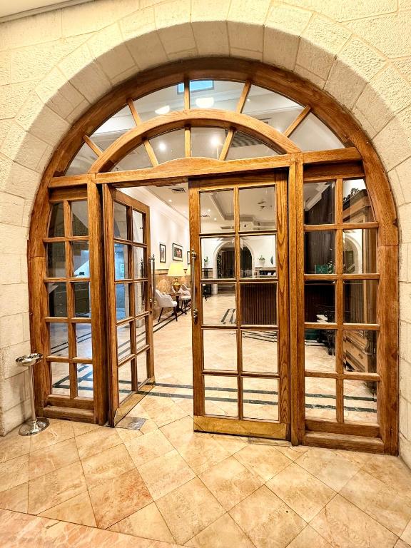 an arched glass door in a room with a stone wall at Christmas Hotel - Jerusalem in Jerusalem