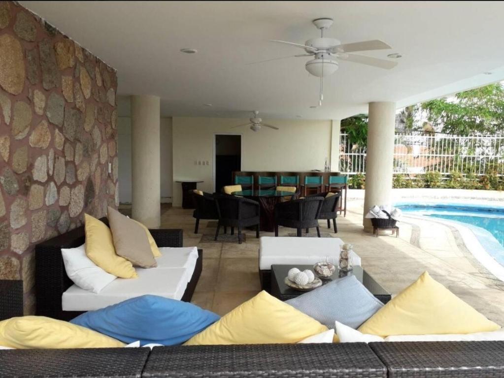 a living room with white couches and a pool at Private villa, 6 bedrooms, 2 pools with views in Acapulco