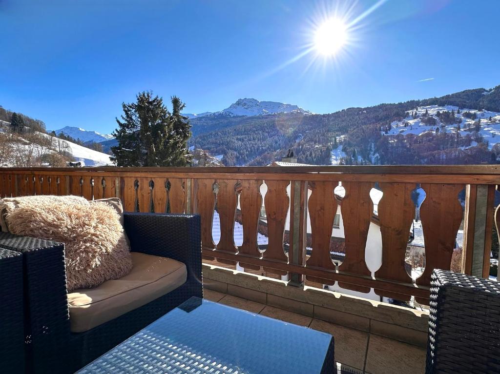 a balcony with a chair and a table with a view at Chalet apartment & mountain view in Saas
