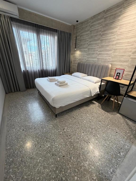 a bedroom with a large white bed and a desk at athensdot in Athens