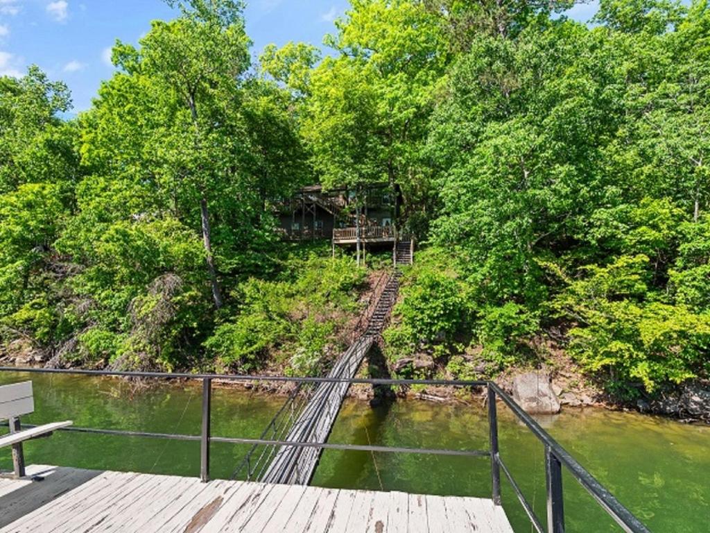 a wooden bridge over a river with trees at Smith Lake Retreat - Close To Trident Marina in Crane Hill