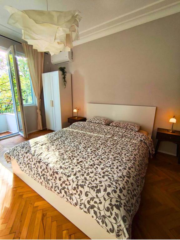 a bedroom with a bed with a black and white comforter at Serenity and cosy Lodge, next to NDK! in Sofia