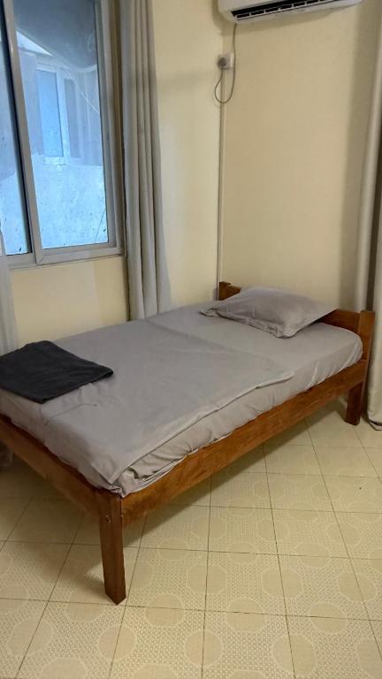 a wooden bed in a room with a window at Noorhaven stay in Watamu