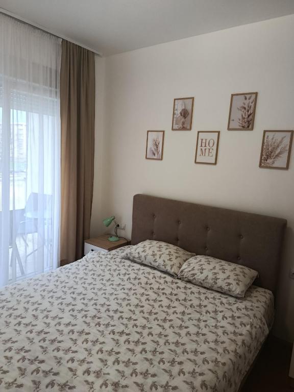 a bedroom with a bed and some pictures on the wall at Aura Trebinje in Trebinje