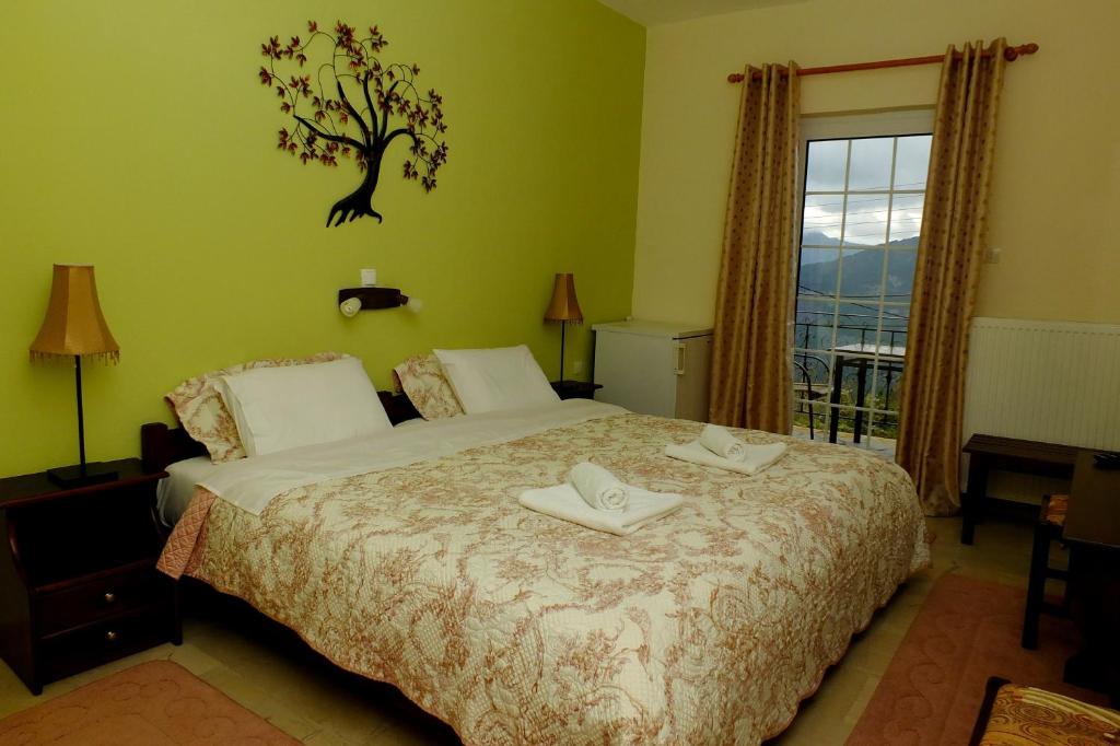 a bedroom with a bed and a tree on the wall at Ksenonas Biktoria in Loutra Amarantou