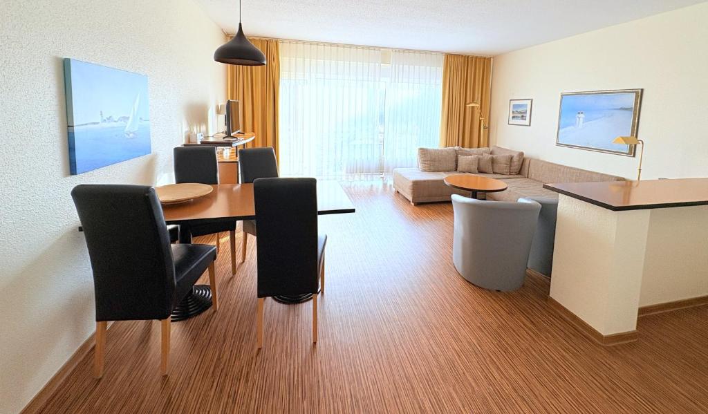 a living room with a table and chairs and a couch at Boddenhof Apartment 48 - Terrasse für Hundefreunde in Buschvitz