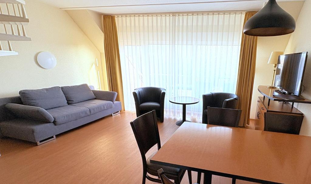 a living room with a couch and a table at Boddenhof Apartment 54 - Balkon, Parkplatz, ruhig in Stedar