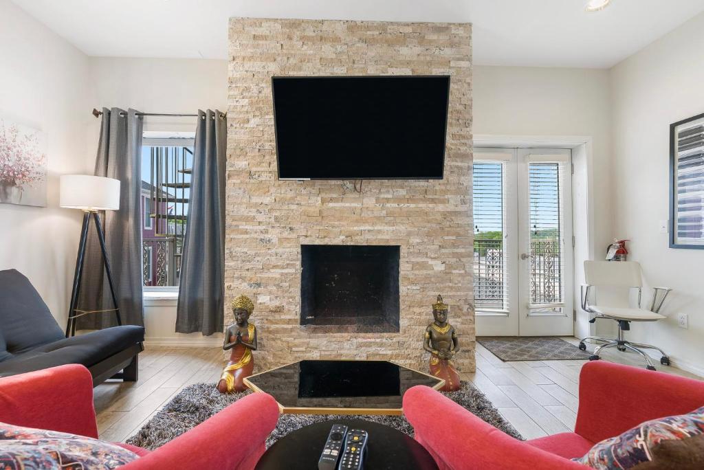 a living room with a fireplace with a flat screen tv at Contemporary Dual-Unit 2BR Downtown Branson - Free Tickets Included - LOFT in Branson