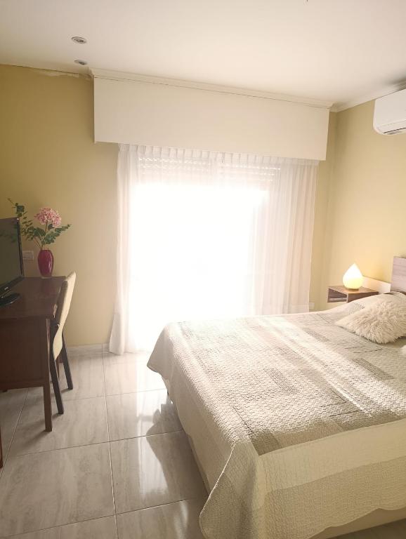 a bedroom with a bed and a desk and a window at Céntrico con cochera in Coronel Suárez