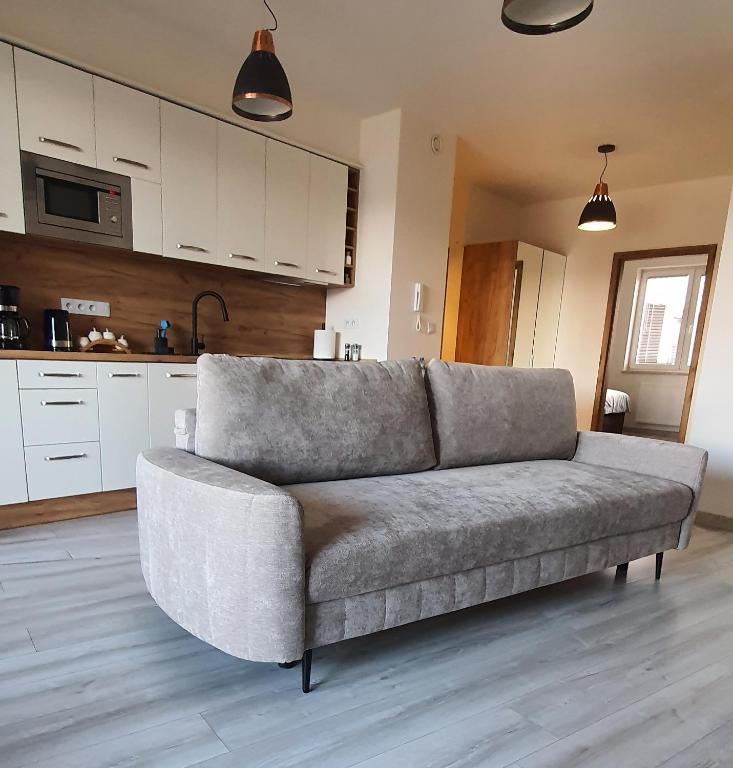 a couch in a living room with a kitchen at PIANISSIMO in Krakow