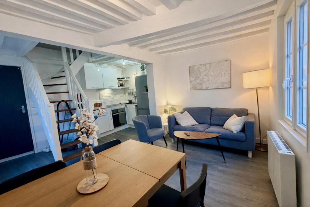 a living room with a blue couch and a table at Le Duplex 4p - 2 chambres, centre Compiègne in Compiègne