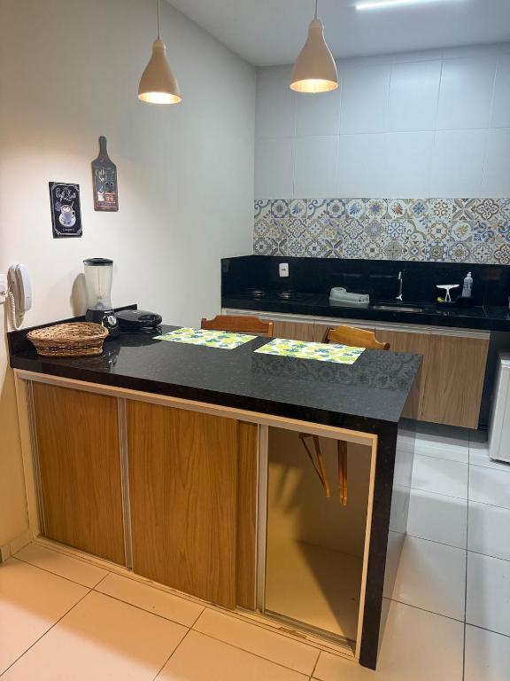 a kitchen with a counter with a black counter top at Loft Dominguinhos in Campina Grande
