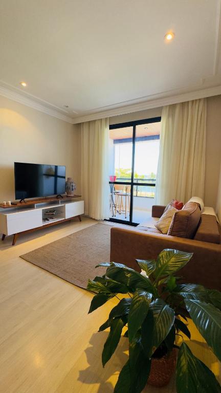a living room with a couch and a flat screen tv at Apê com vista para o mar e clima animado in Vitória