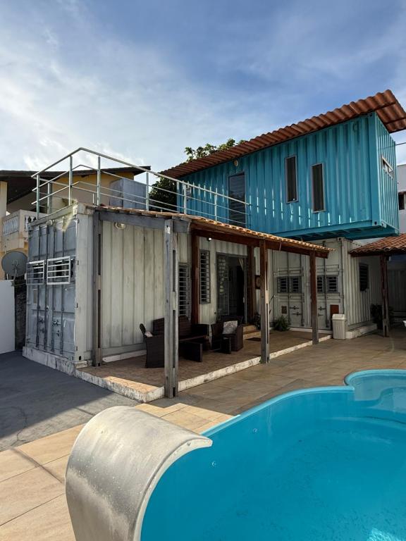 a house with a swimming pool in front of a house at Conteiner House in Pipa