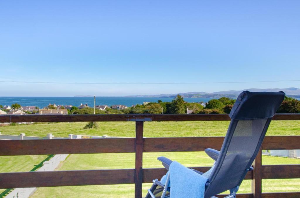 a blue chair sitting on a porch overlooking the ocean at 4 Bed in Moelfre oc-wai202 in Moelfre