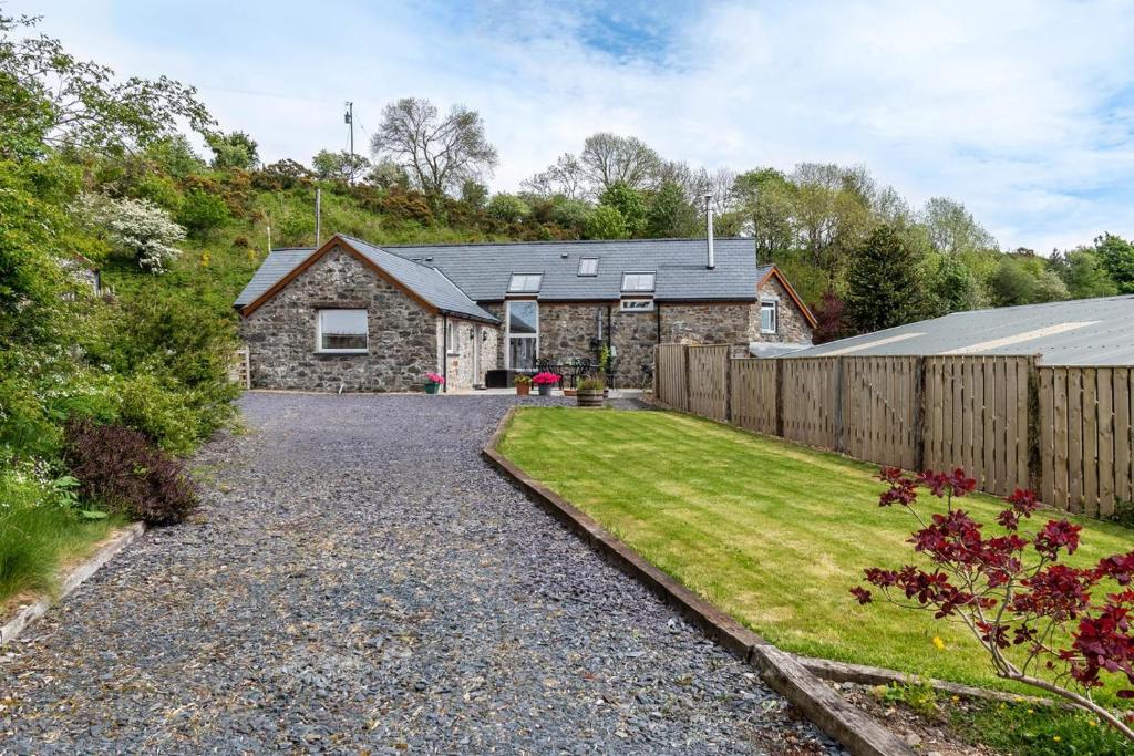 a stone house with a fence and a yard at 3 Bed in Corwen oc-fl009 in Derwen