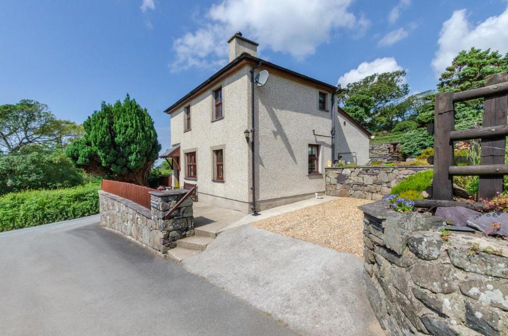 a large white house with a stone wall at 3 Bed in Caernarfon oc-wag443 in Llanwnda