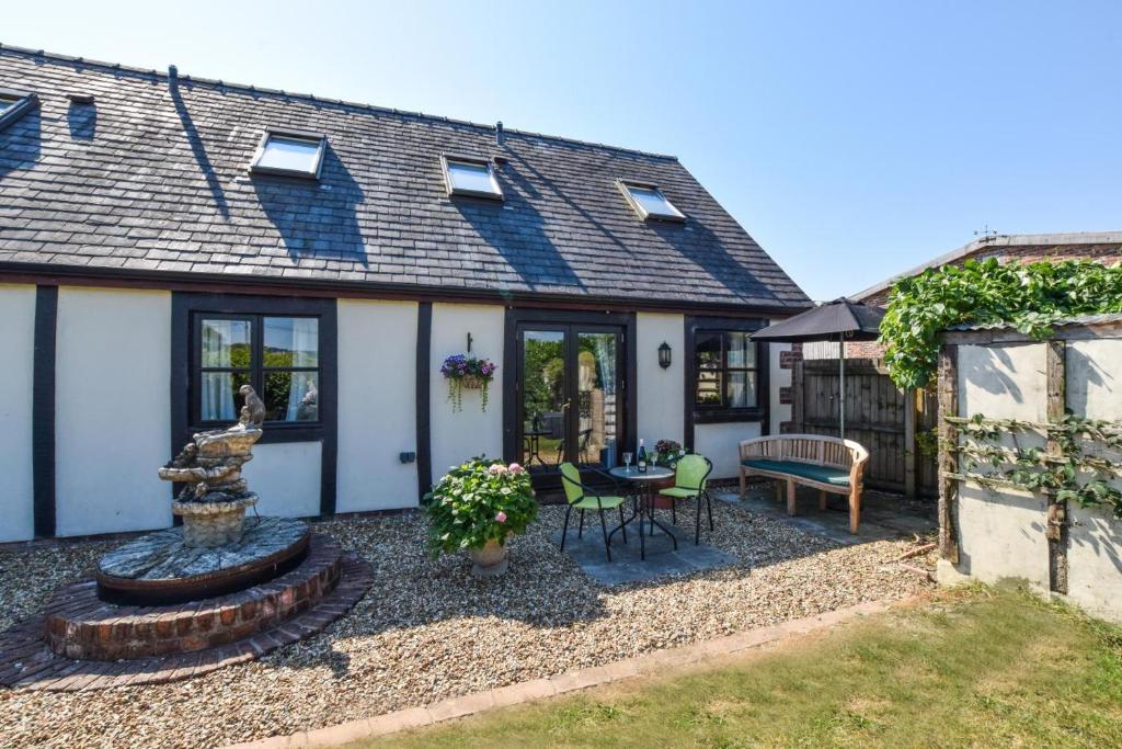 a home with a patio and a fountain in the yard at 1 Bed in Welshpool oc-75714 in Meifod