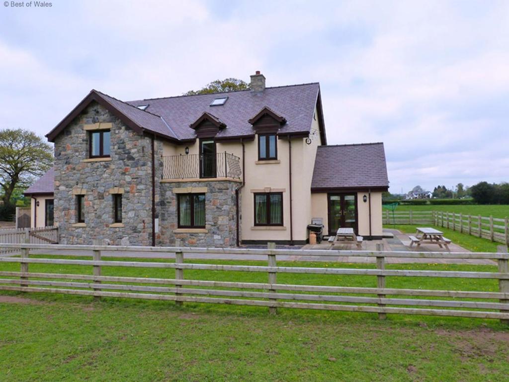 a large house with a fence in front of it at 7 Bed in Caerwys oc-58357 in Caerwys