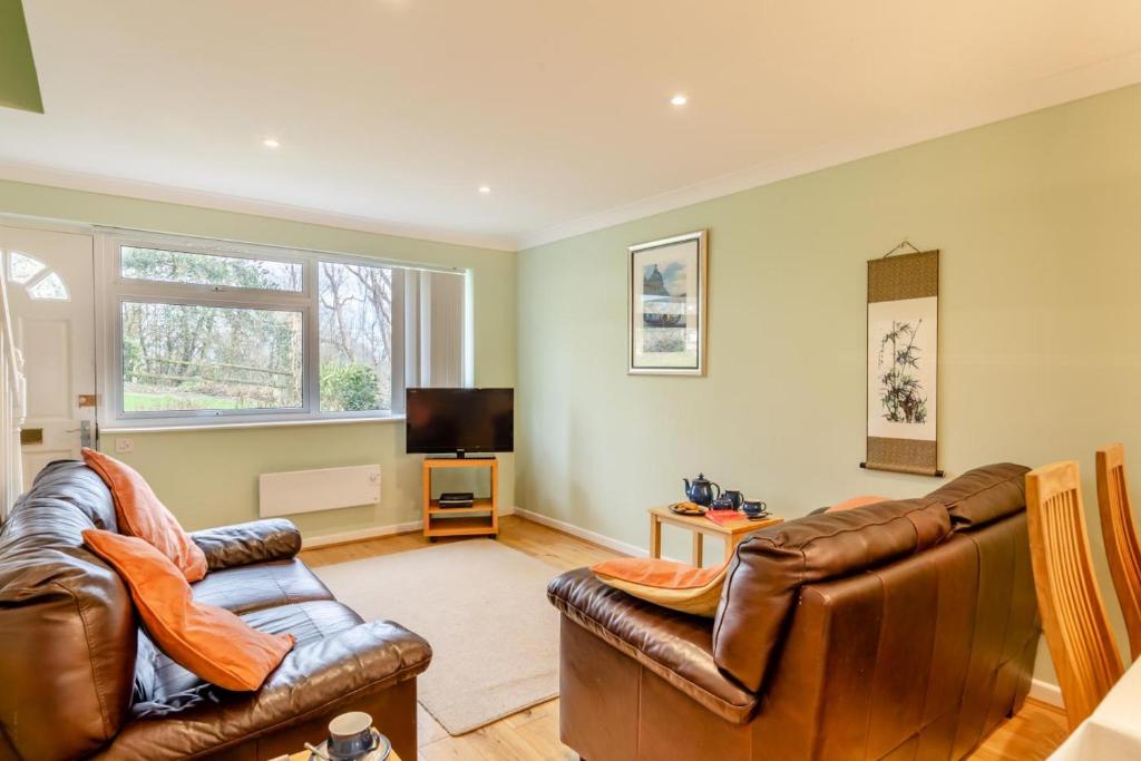 a living room with two leather couches and a television at 2 Bed in Charmouth oc-wy395 in Charmouth