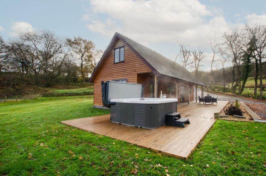 a hot tub on a deck next to a house at 3 Bed in Bala oc-bow162 in Bala