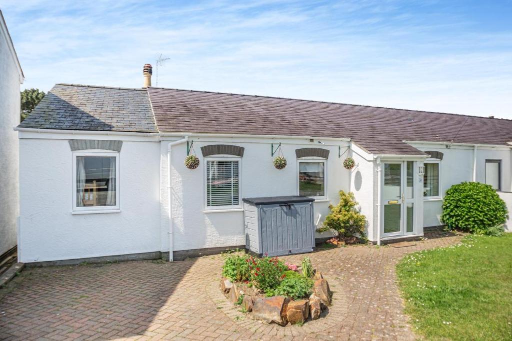 a white house with a driveway in front of it at 4 Bed in Morfa Nefyn oc-bow10 in Morfa Nefyn