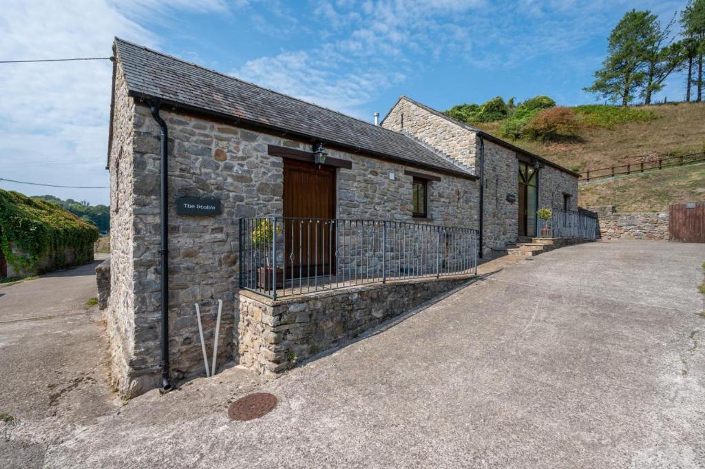 a stone house with a gate and a driveway at 1 Bed in Gower oc-hh408 in Llanmadoc