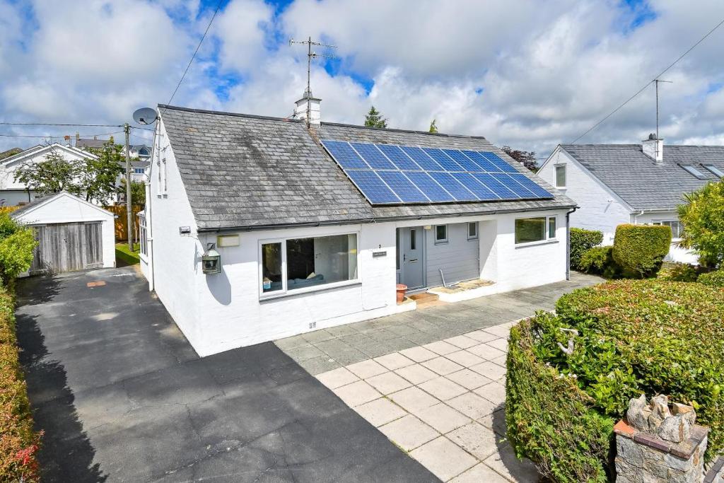 a white house with solar panels on the roof at 4 Bed in Pwllheli oc-morgra in Abersoch