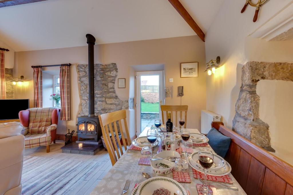 a dining room with a table and a fireplace at 3 Bed in Benllech oc-24195 in Benllech