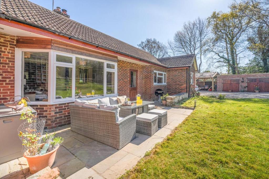 a patio with a couch and chairs in a yard at 4 Bed in Godalming oc-b30296 in Hook
