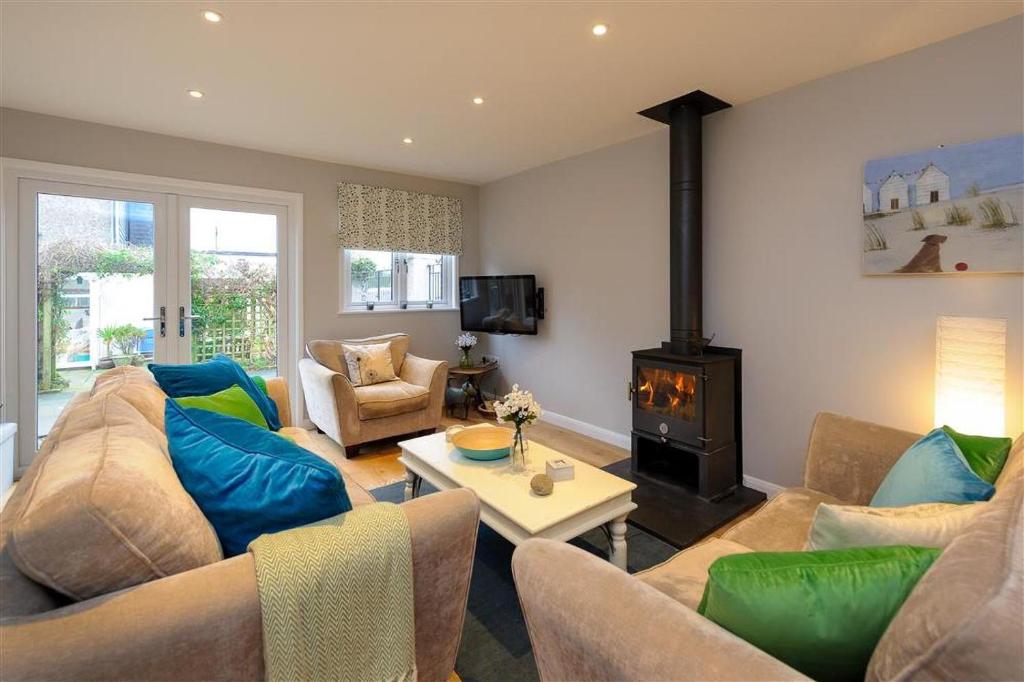 a living room with a couch and a stove at 4 Bed in Pwllheli oc-lluest in Abersoch