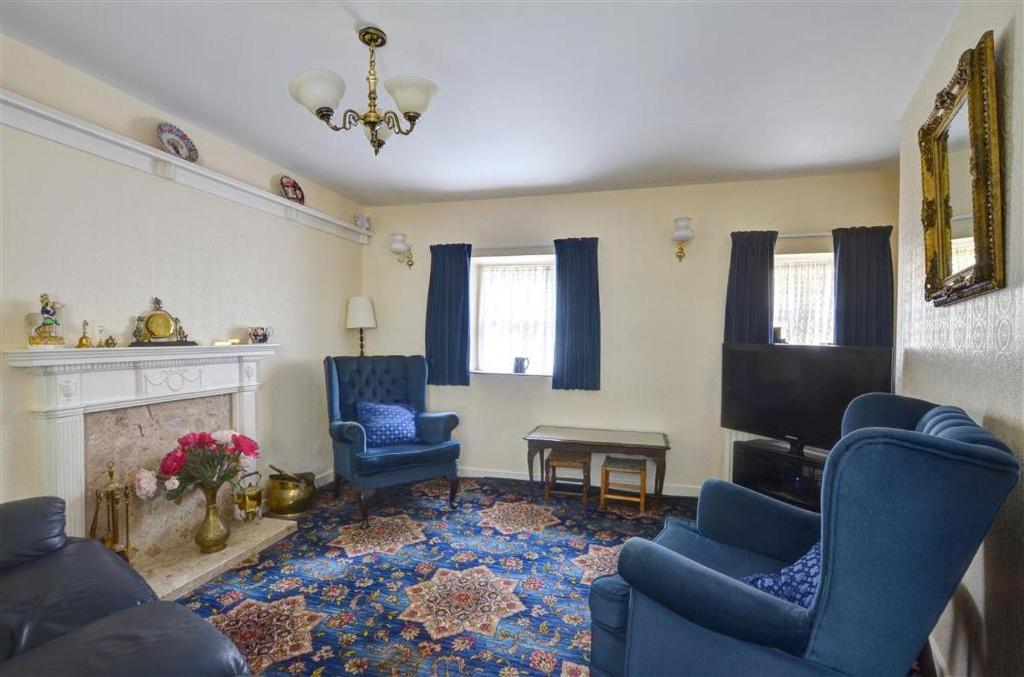 a living room with blue chairs and a fireplace at 2 Bed in Caernarfon oc-wag359 in Caernarfon