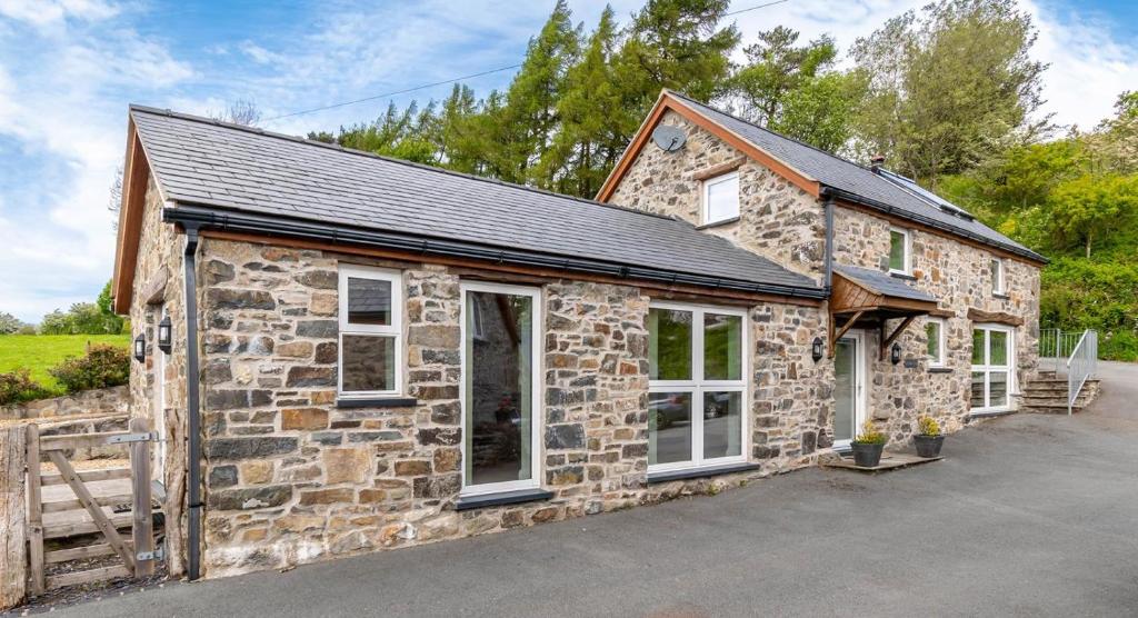 a stone house with a black roof at 1 Bed in Corwen oc-fl010 in Derwen