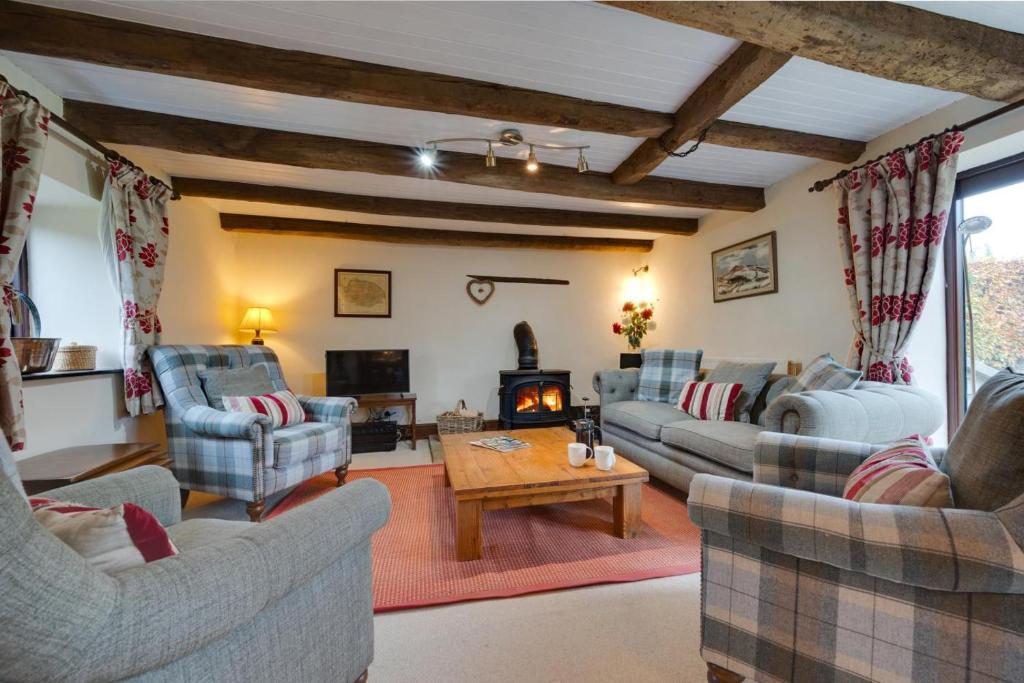 a living room with couches and a table and a fireplace at 3 Bed in Binham oc-2235 in Binham