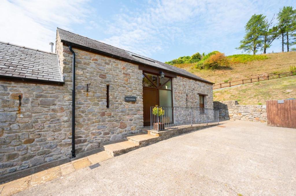 an old stone building with a large driveway at 3 Bed in Gower oc-hh407 in Llanmadoc