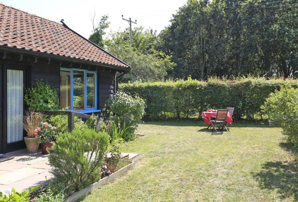 a garden with a house and a table and chairs at 1 Bed in Beccles oc-mcn in Henstead