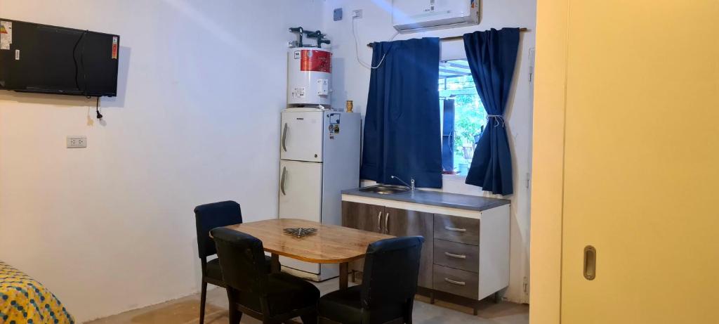 a small kitchen with a table and a refrigerator at Tres Hermanos in Trinidad