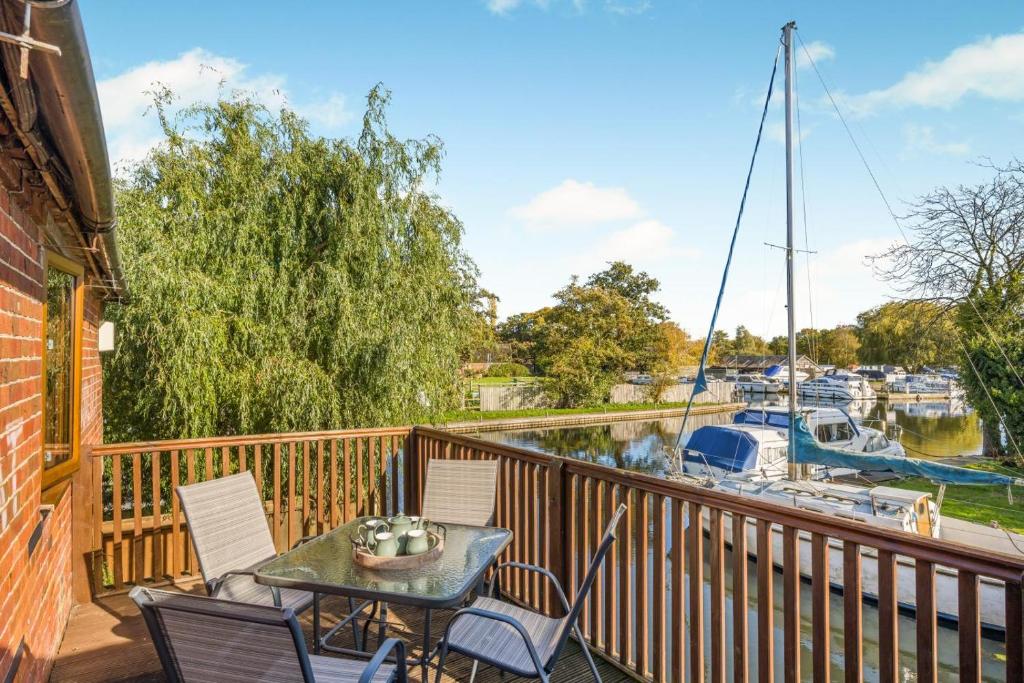 a balcony with a table and chairs and a marina at 2 Bed in Smallburgh oc-h33733 in Dilham