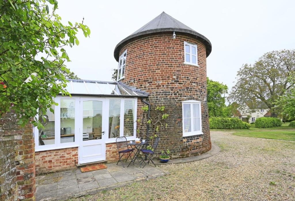 a brick house with a round window and a turret at 1 Bed in Wickham Market oc-samp in Wickham Market